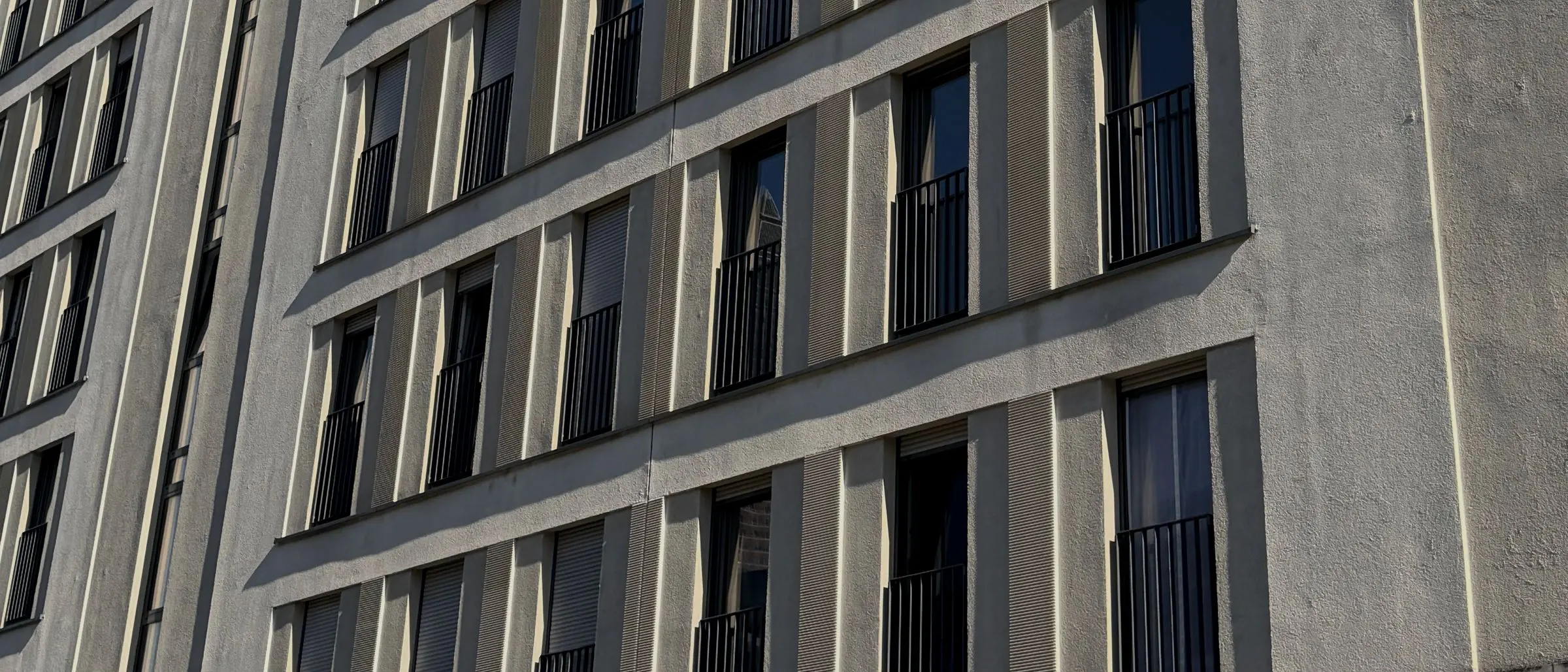 Façade grid of a large apartment building with French balconies